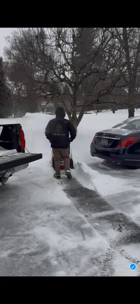 Green Life Landscape Services crew clearing a residential driveway with a snow blower in Havertown PA